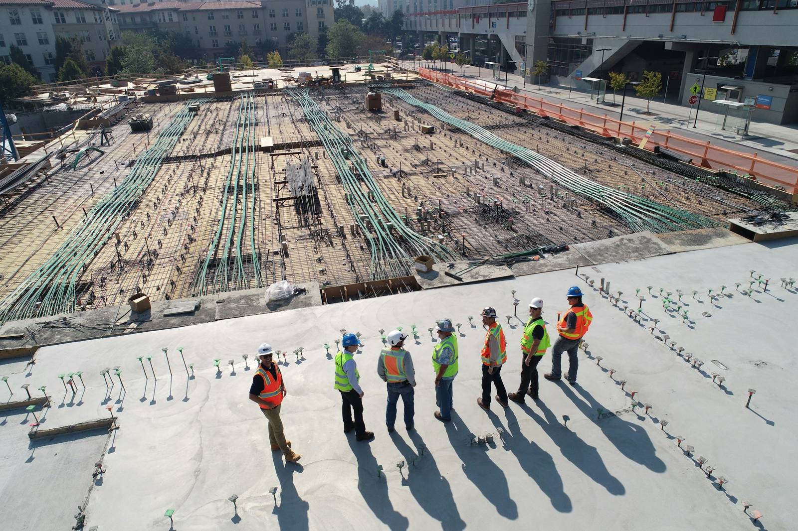 Site crew in vests and hard hats on a roof
