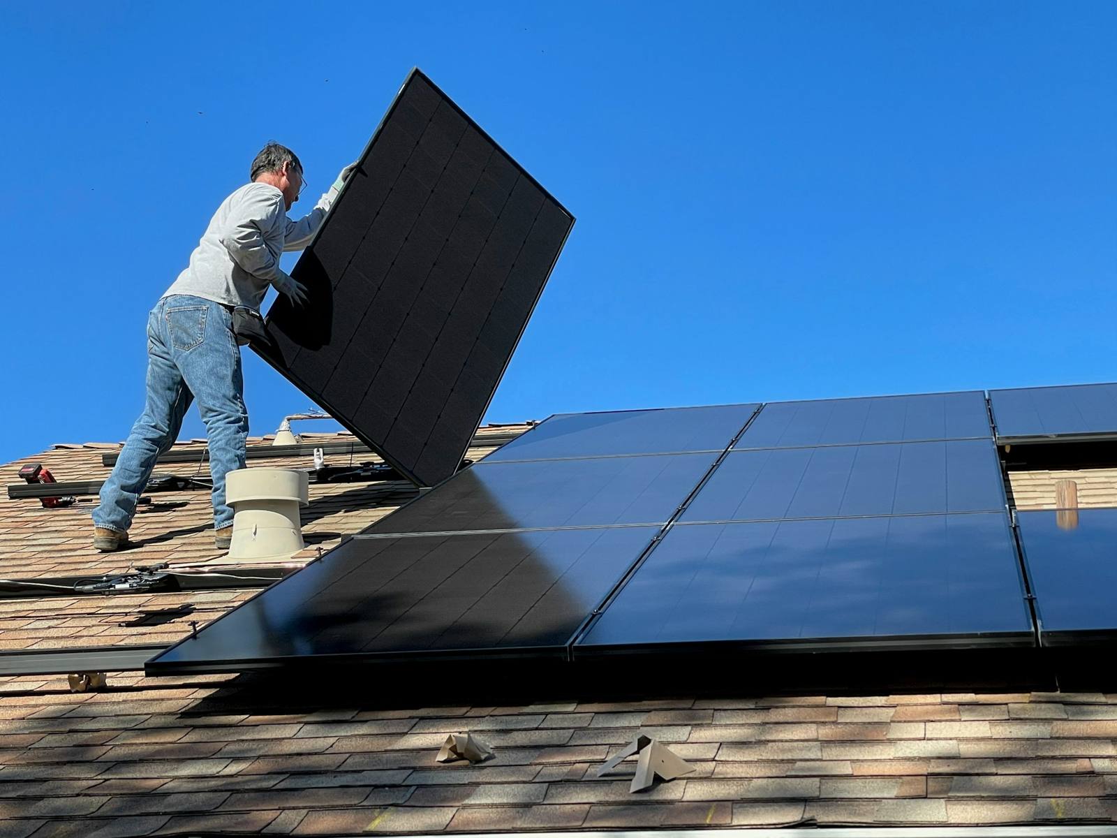 Instalador colocando un módulo solar en la cubierta de una vivienda
